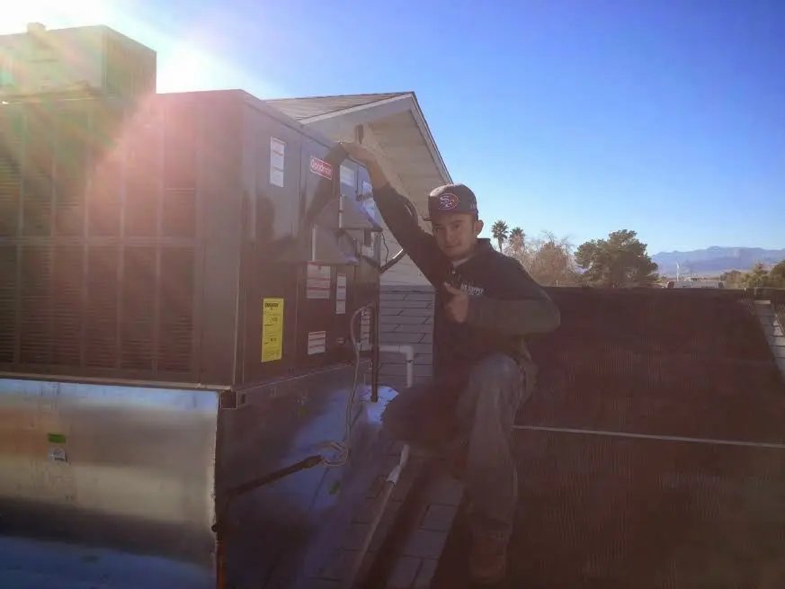 HVAC technician performing AC Tune-Up on a rooftop unit in Cartersville